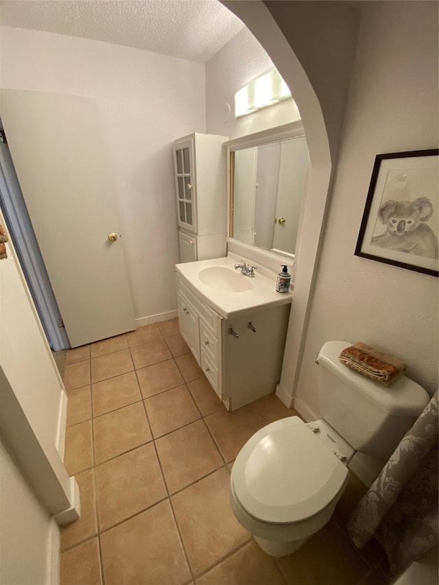 bathroom featuring tile patterned floors, vanity, toilet, and a textured ceiling