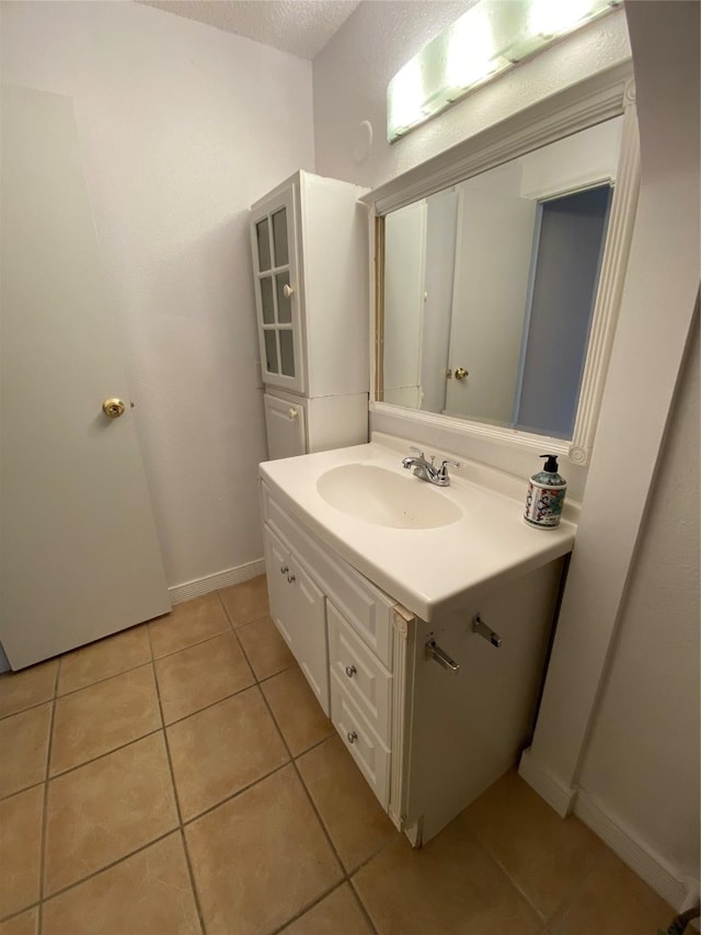 bathroom with tile patterned flooring, vanity, and baseboards