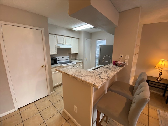 kitchen featuring white range with electric cooktop, a sink, under cabinet range hood, and light tile patterned floors