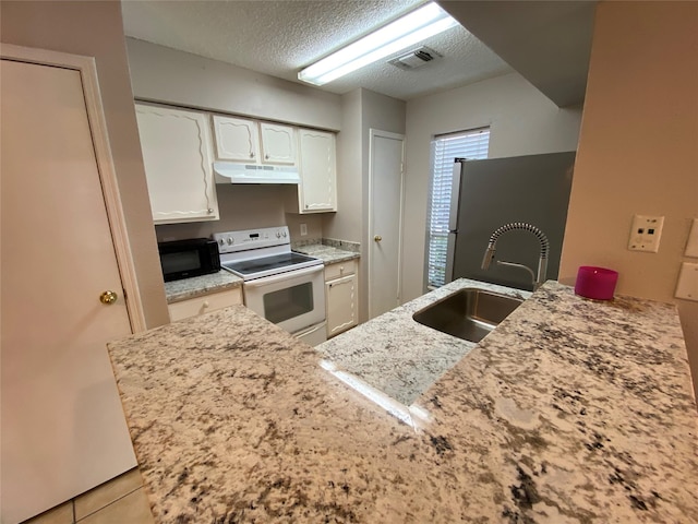 kitchen with white range with electric stovetop, freestanding refrigerator, a sink, black microwave, and under cabinet range hood