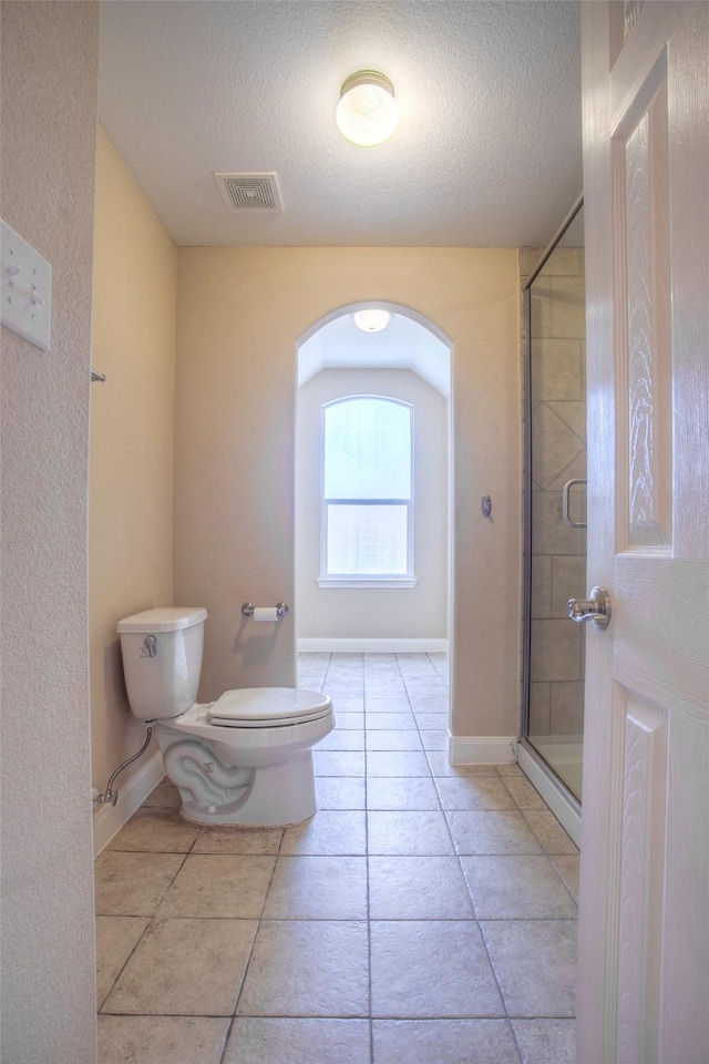 1634 Topaz Trl, Willis, TX 77378 - full bath with toilet, a textured ceiling, a shower stall, baseboards, and tile patterned flooring