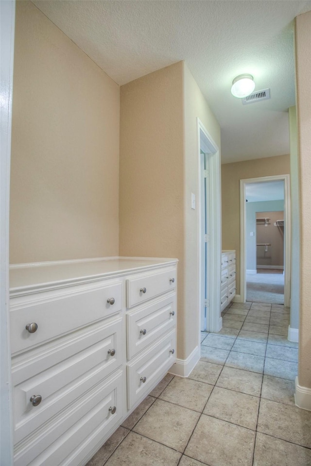 1634 Topaz Trl, Willis, TX 77378 - hallway featuring light tile patterned flooring, baseboards, and a textured ceiling