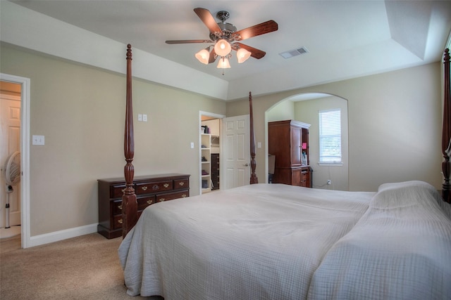 1634 Topaz Trl, Willis, TX 77378 - bedroom featuring light carpet, arched walkways, baseboards, a ceiling fan, and a walk in closet