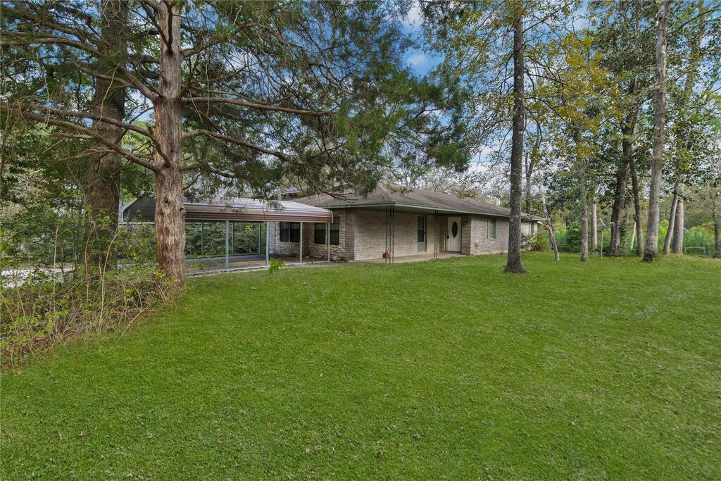 180 King Arthur Ct, Woodville, TX 75979 - back of house featuring a yard and an attached carport
