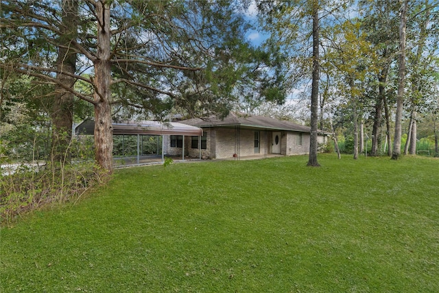 back of house featuring a yard and an attached carport