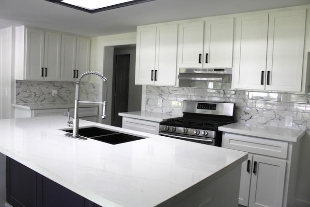 213 Red Haven Dr, Highlands, TX 77562 - kitchen featuring gas stove, under cabinet range hood, a sink, decorative backsplash, and a kitchen island with sink