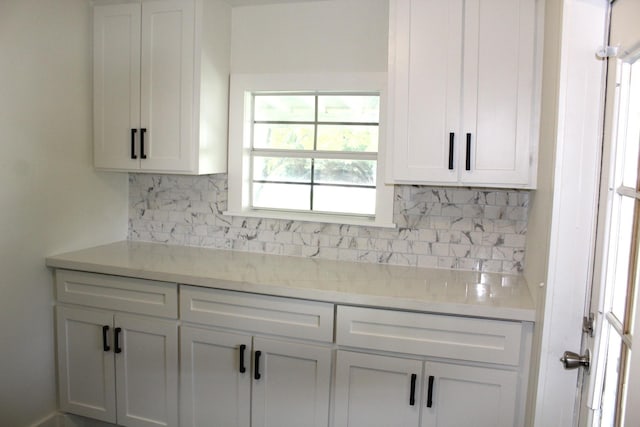 213 Red Haven Dr, Highlands, TX 77562 - kitchen with backsplash, white cabinetry, and light stone countertops