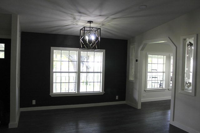213 Red Haven Dr, Highlands, TX 77562 - unfurnished dining area featuring arched walkways, baseboards, dark wood-style floors, and a chandelier