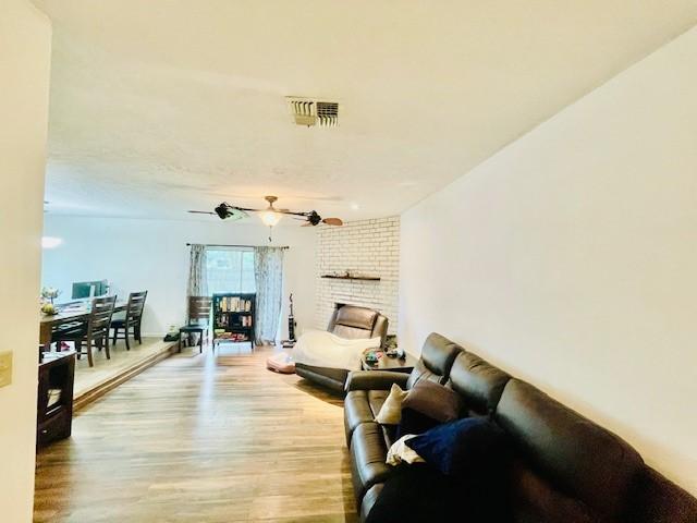 2122 Clemson Dr, Katy, TX 77493 - living room featuring a fireplace, light wood finished floors, and visible vents