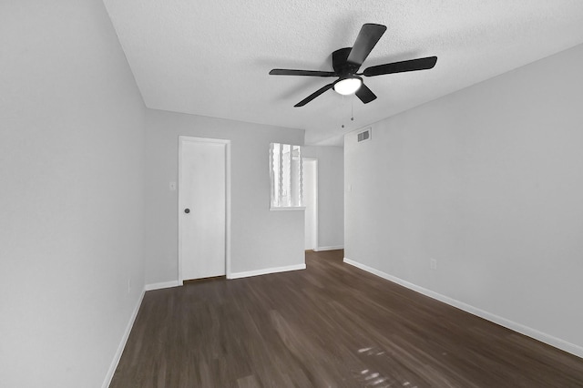 unfurnished room featuring a ceiling fan, a textured ceiling, visible vents, baseboards, and dark wood-style flooring