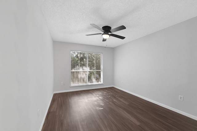 unfurnished room featuring a textured ceiling, baseboards, dark wood-style floors, and a ceiling fan
