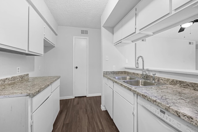 kitchen featuring white dishwasher, a textured ceiling, visible vents, a sink, and white cabinetry