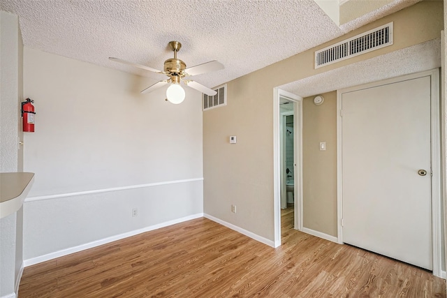 unfurnished room featuring baseboards, ceiling fan, visible vents, and wood finished floors