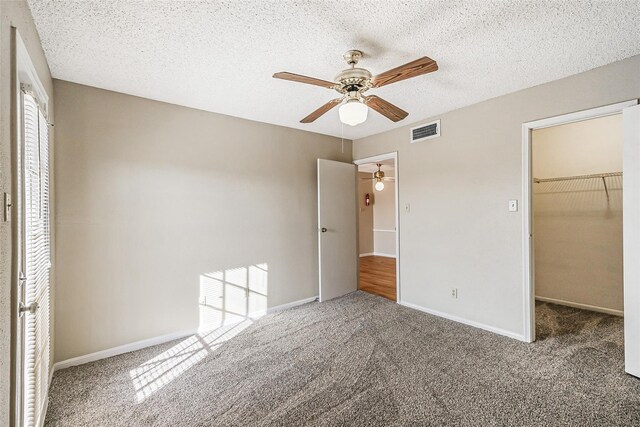 unfurnished bedroom with a spacious closet, carpet flooring, and visible vents