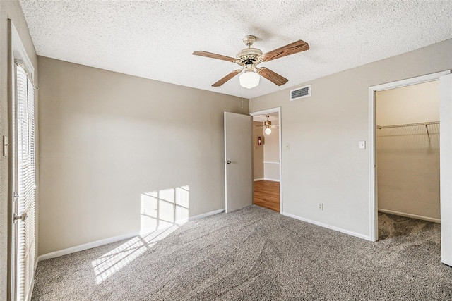 unfurnished bedroom with a spacious closet, carpet flooring, and visible vents