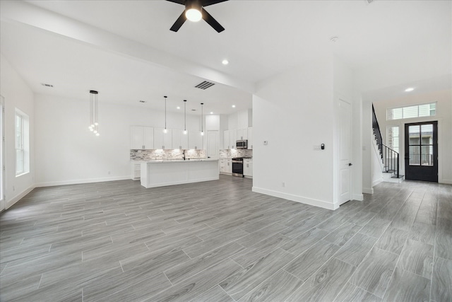 10935 Brookeshire Chase Ln, Houston, TX 77043 - unfurnished living room featuring stairs, ceiling fan, baseboards, light wood-type flooring, and recessed lighting