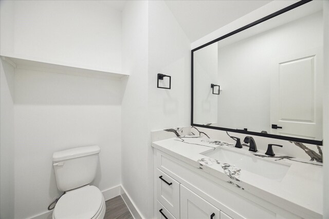 10935 Brookeshire Chase Ln, Houston, TX 77043 - half bathroom featuring toilet, vanity, baseboards, and wood finished floors