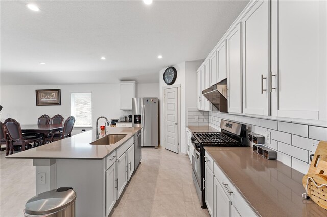30102 Reagans Ranch Dr, Katy, TX 77494 - kitchen featuring a sink, stainless steel appliances, recessed lighting, an island with sink, and decorative backsplash