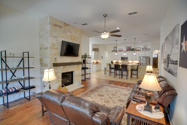 4803 Birch Grove Dr, Fulshear, TX 77441 - living area featuring ceiling fan, light wood-style floors, and a fireplace