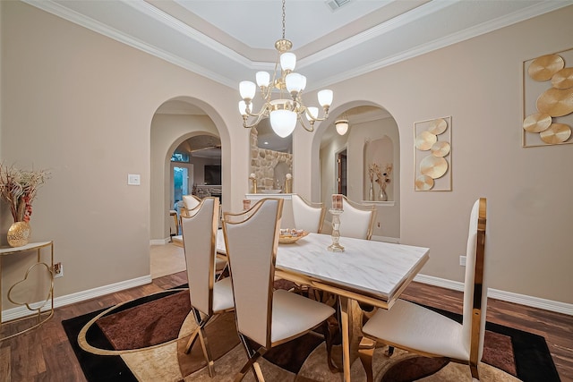 122 Marble Staff Ct, Houston, TX 77069 - dining space with arched walkways, wood finished floors, a chandelier, baseboards, and crown molding