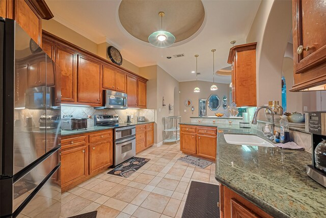122 Marble Staff Ct, Houston, TX 77069 - kitchen with stainless steel appliances, decorative backsplash, a sink, brown cabinets, and crown molding