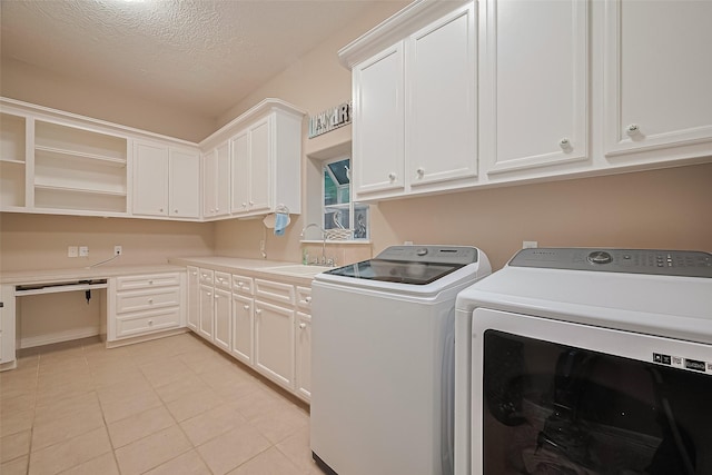 122 Marble Staff Ct, Houston, TX 77069 - clothes washing area featuring separate washer and dryer, cabinet space, a textured ceiling, and light tile patterned floors