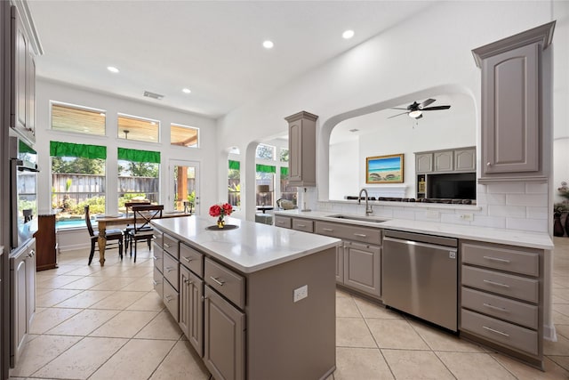 15306 Clearhaven Ct, Cypress, TX 77429 - kitchen featuring a sink, stainless steel appliances, arched walkways, a center island, and gray cabinetry