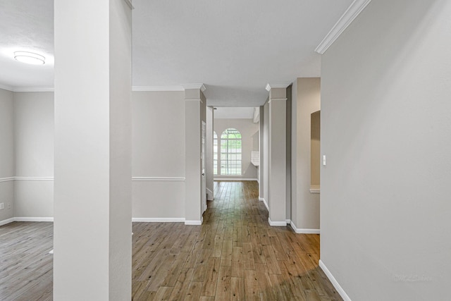 hall featuring baseboards, crown molding, and wood finished floors