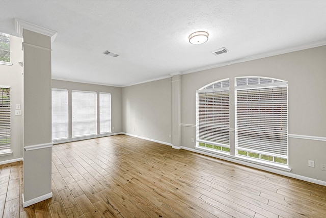 interior space with crown molding, visible vents, wood finished floors, and baseboards