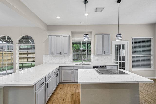 kitchen with a sink, black electric stovetop, visible vents, decorative backsplash, and gray cabinetry