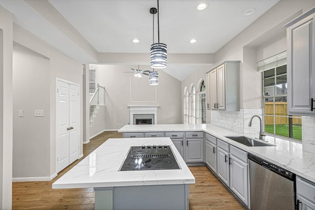 kitchen featuring a ceiling fan, a sink, stainless steel dishwasher, gray cabinetry, and black electric stovetop