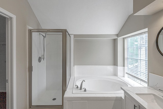 bathroom featuring vaulted ceiling, vanity, a garden tub, and a shower stall
