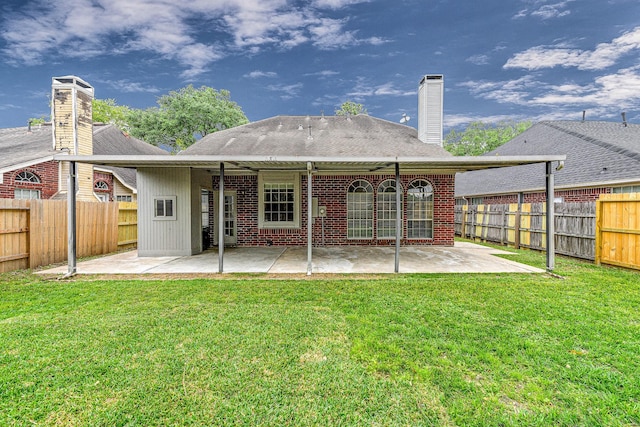 back of house with a fenced backyard, a patio, and a lawn