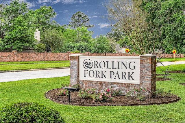 community sign featuring a lawn