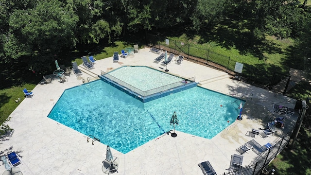 community pool featuring fence and a patio area