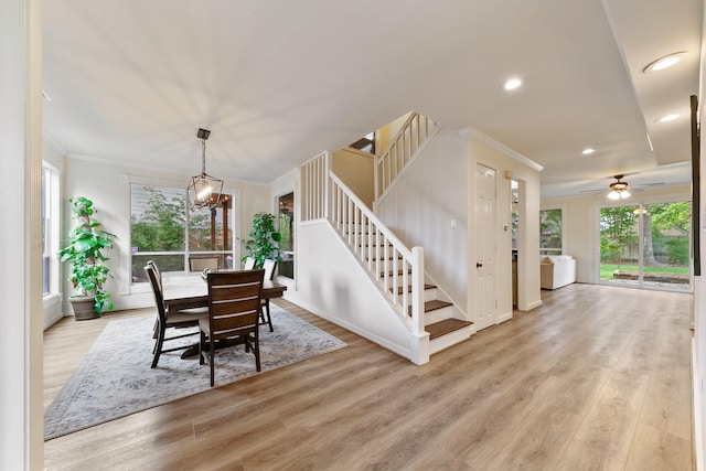 dining area with crown molding, stairway, light wood-style flooring, recessed lighting, and a chandelier