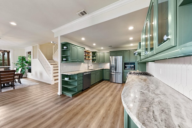 kitchen featuring open shelves, green cabinets, stainless steel appliances, decorative backsplash, and crown molding
