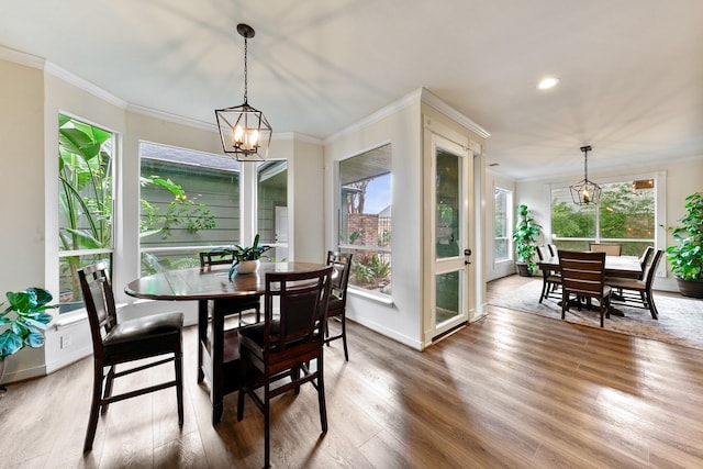 dining space featuring a chandelier, wood finished floors, ornamental molding, baseboards, and recessed lighting