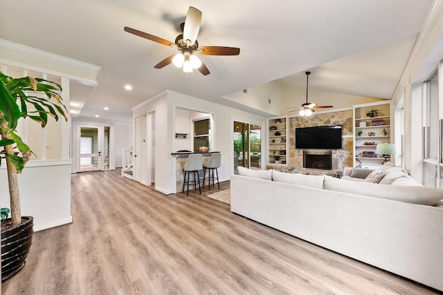 living room featuring a ceiling fan, a stone fireplace, wood finished floors, recessed lighting, and built in shelves