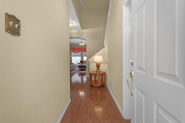 corridor featuring baseboards and wood finished floors