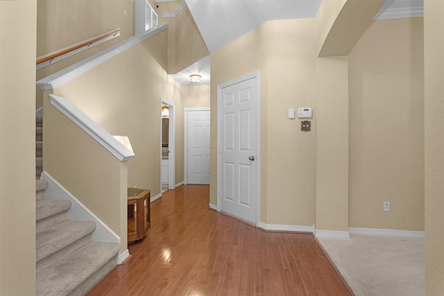 foyer featuring stairway, baseboards, and wood finished floors