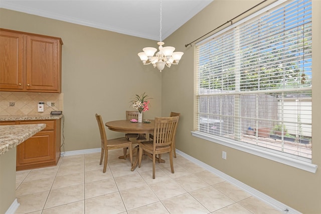 dining space with an inviting chandelier, crown molding, baseboards, and light tile patterned floors