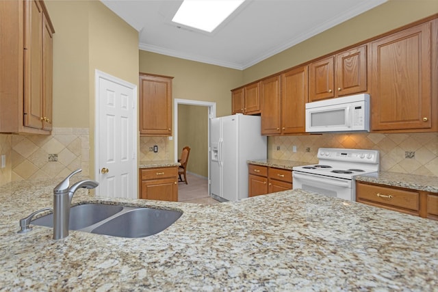 kitchen with white appliances, light stone counters, a sink, crown molding, and backsplash