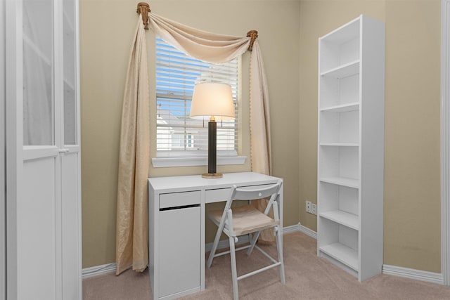 office space featuring light carpet and baseboards