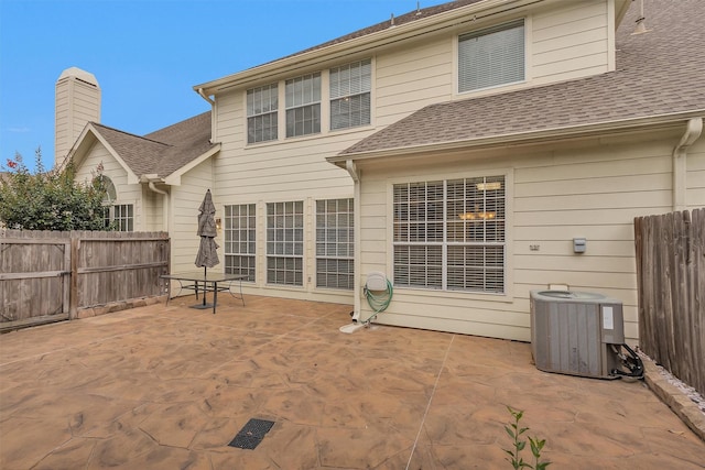back of property with central AC unit, a patio, and fence