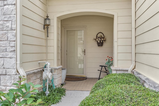 entrance to property featuring a porch and stone siding