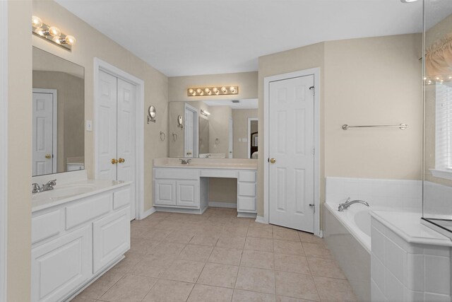 bathroom with two vanities, tile patterned floors, a closet, and a sink