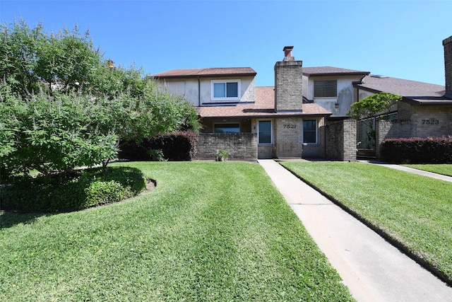 7521 Beaudelaire Cir, Galveston, TX 77551 - view of front facade with a front lawn, stucco siding, and a chimney
