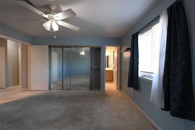 7521 Beaudelaire Cir, Galveston, TX 77551 - unfurnished bedroom with light colored carpet, a ceiling fan, ensuite bath, a closet, and baseboards