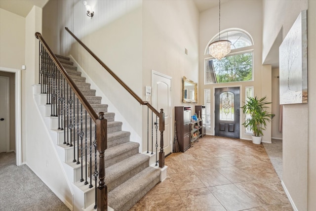 13921 Pebble Falls Ln, Pearland, TX 77584 - entryway with a towering ceiling, stairs, a chandelier, and baseboards